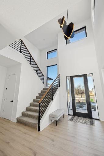 Amazing 19' ceilings at foyer with 8' doors and modern spindles at stairs.
