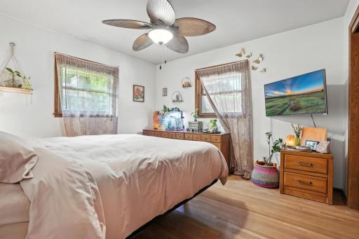 Primary bedroom with hardwood floors and newer windows
