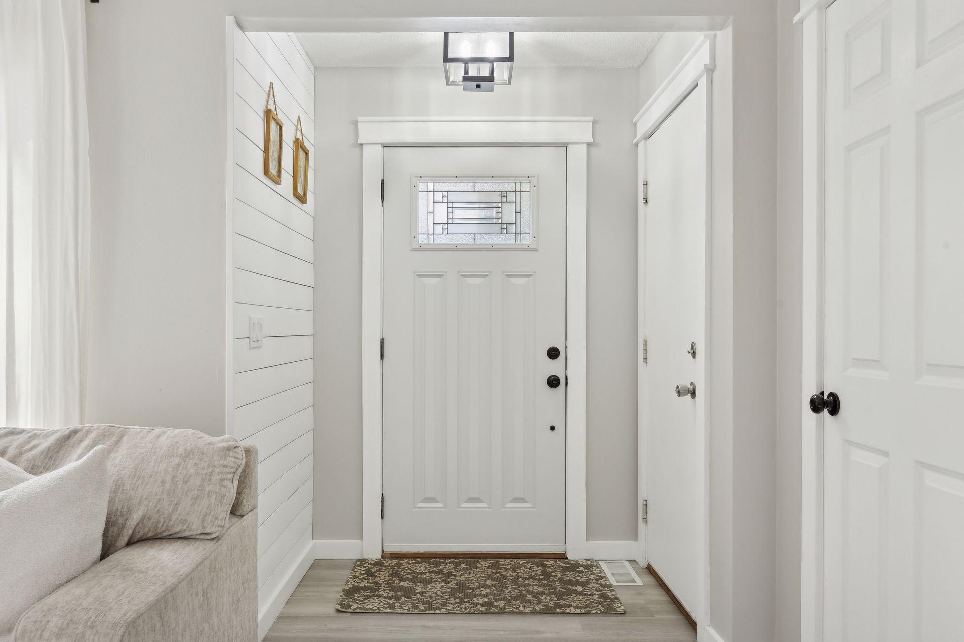 20x20 Main Level Living room with updated styling, Fresh paint, new flooring, white trim and a shiplap-wrapped Electric Fireplace. West-facing windows.