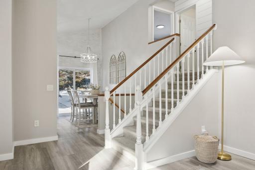 16x12 Main Level Kitchen updated with refaced white cabinetry in 2020, New dishwasher in 2024, new quartz countertops and backsplash, Fresh paint, new flooring, and white trim. North-facing windows and a sliding glass door to the side yard.