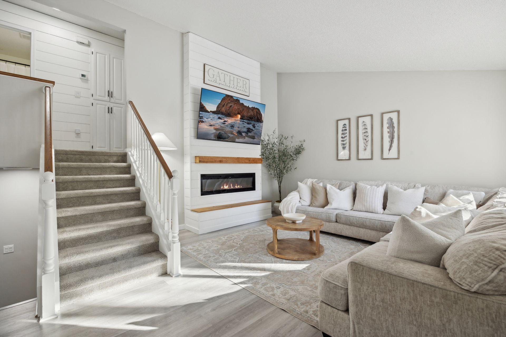 20x20 Main Level Living room with updated styling, Fresh paint, new flooring, white trim and a shiplap-wrapped Electric Fireplace. West-facing windows.