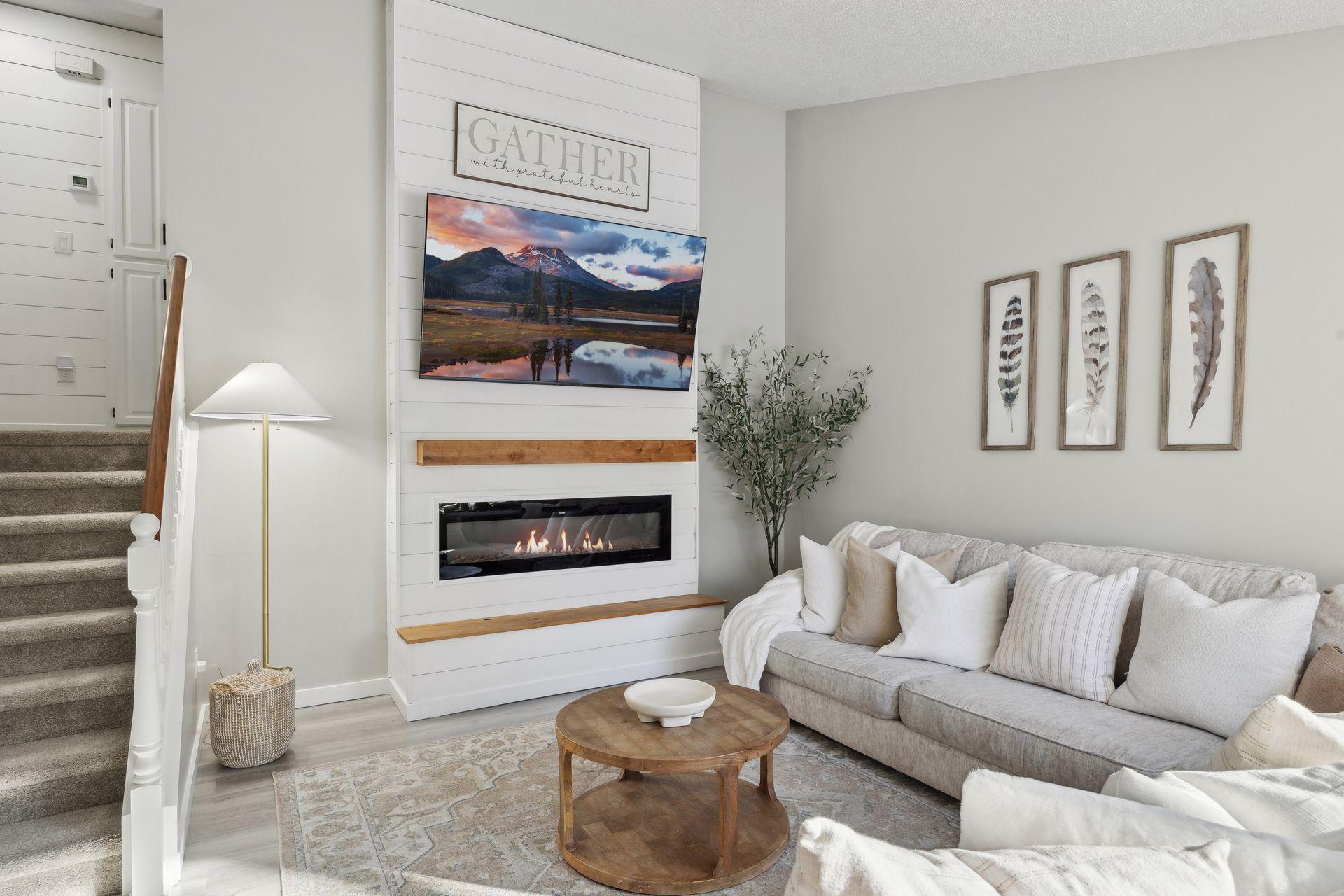 20x20 Main Level Living room with updated styling, Fresh paint, new flooring, white trim and a shiplap-wrapped Electric Fireplace. West-facing windows.