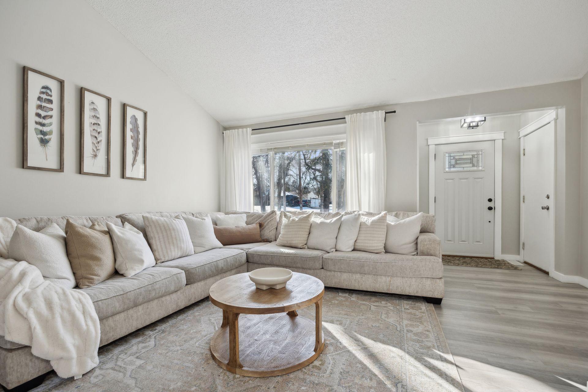 20x20 Main Level Living room with updated styling, Fresh paint, new flooring, white trim and a shiplap-wrapped Electric Fireplace. West-facing windows.