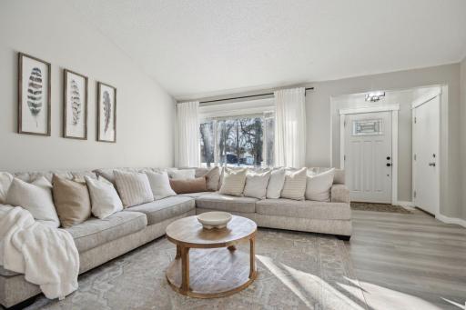 20x20 Main Level Living room with updated styling, Fresh paint, new flooring, white trim and a shiplap-wrapped Electric Fireplace. West-facing windows.