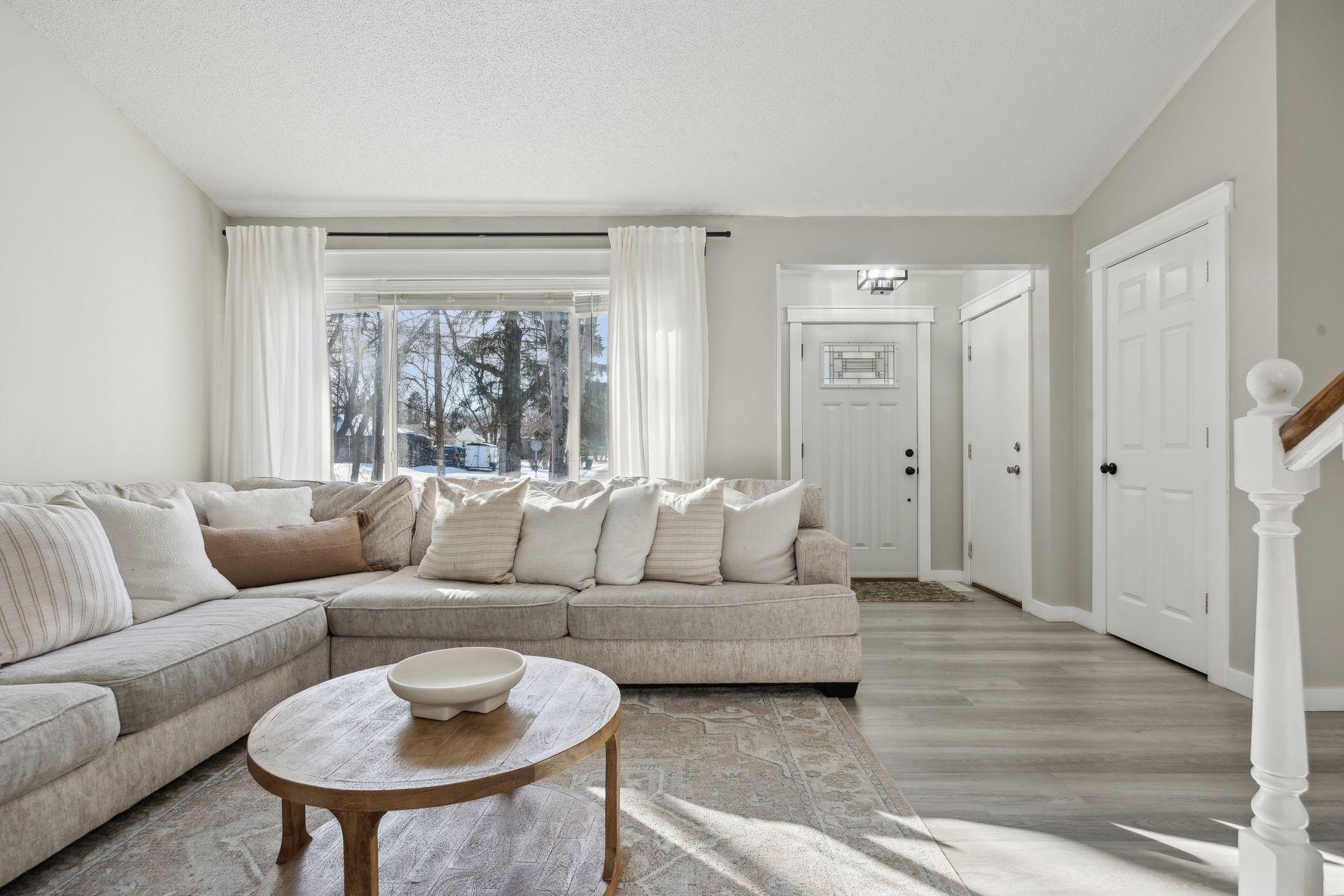 20x20 Main Level Living room with updated styling, Fresh paint, new flooring, white trim and a shiplap-wrapped Electric Fireplace. West-facing windows.