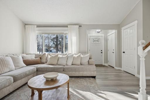 20x20 Main Level Living room with updated styling, Fresh paint, new flooring, white trim and a shiplap-wrapped Electric Fireplace. West-facing windows.
