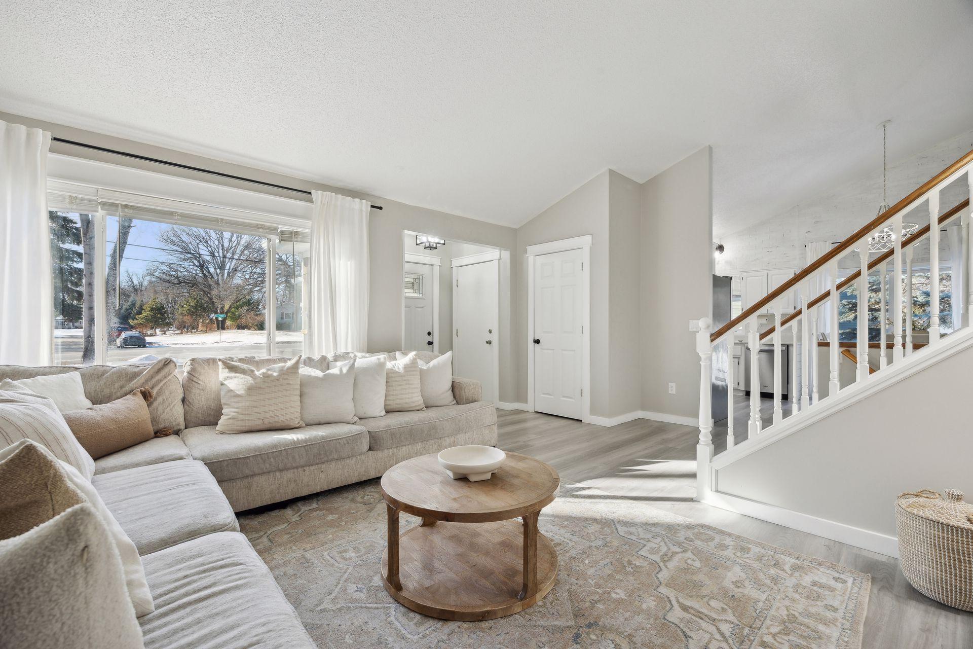 20x20 Main Level Living room with updated styling, Fresh paint, new flooring, white trim and a shiplap-wrapped Electric Fireplace. West-facing windows.