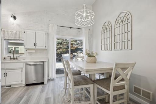 16x12 Main Level Kitchen updated with refaced white cabinetry in 2020, New dishwasher in 2024, new quartz countertops and backsplash, Fresh paint, new flooring, and white trim. North-facing windows and a sliding glass door to the side yard.