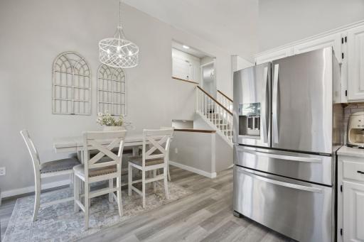 16x12 Main Level Kitchen updated with refaced white cabinetry in 2020, New dishwasher in 2024, new quartz countertops and backsplash, Fresh paint, new flooring, and white trim. North-facing windows and a sliding glass door to the side yard.