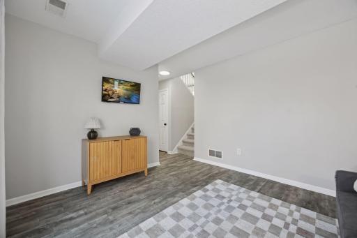 17x11 lower-level family room with East-facing sliding glass doors to back yard, updated flooring, fresh paint and white trim.