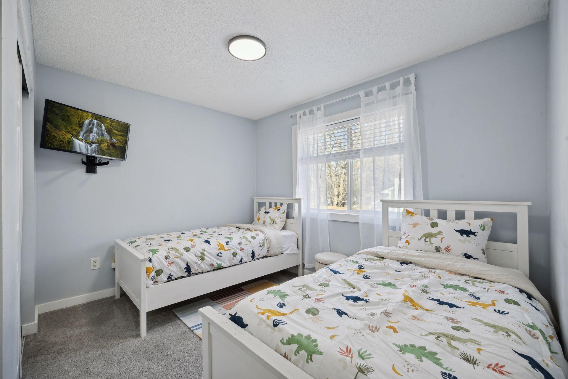 12x11 Upper Level Bedroom #2 with fresh paint and white trim. East-facing windows