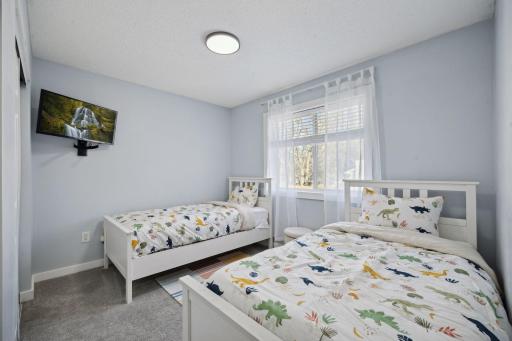 12x11 Upper Level Bedroom #2 with fresh paint and white trim. East-facing windows