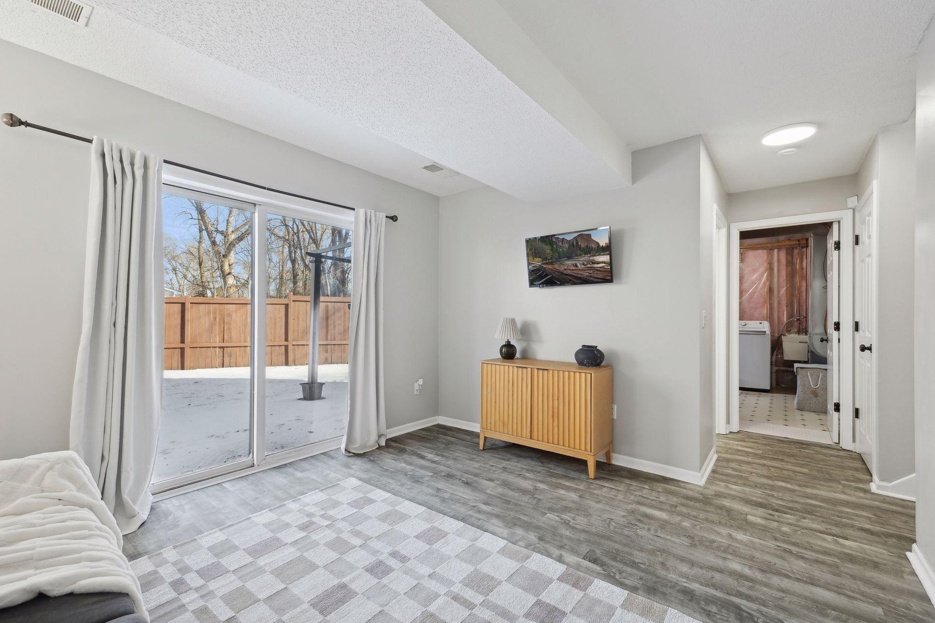 17x11 lower-level family room with East-facing sliding glass doors to back yard, updated flooring, fresh paint and white trim.