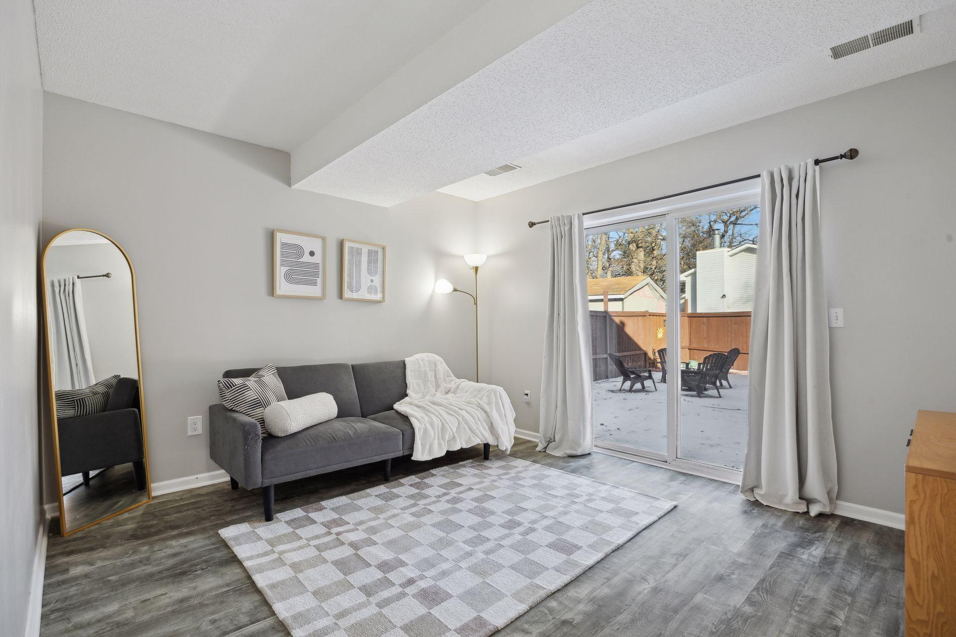 17x11 lower-level family room with East-facing sliding glass doors to back yard, updated flooring, fresh paint and white trim.