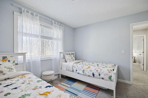 12x11 Upper Level Bedroom #2 with fresh paint and white trim. East-facing windows