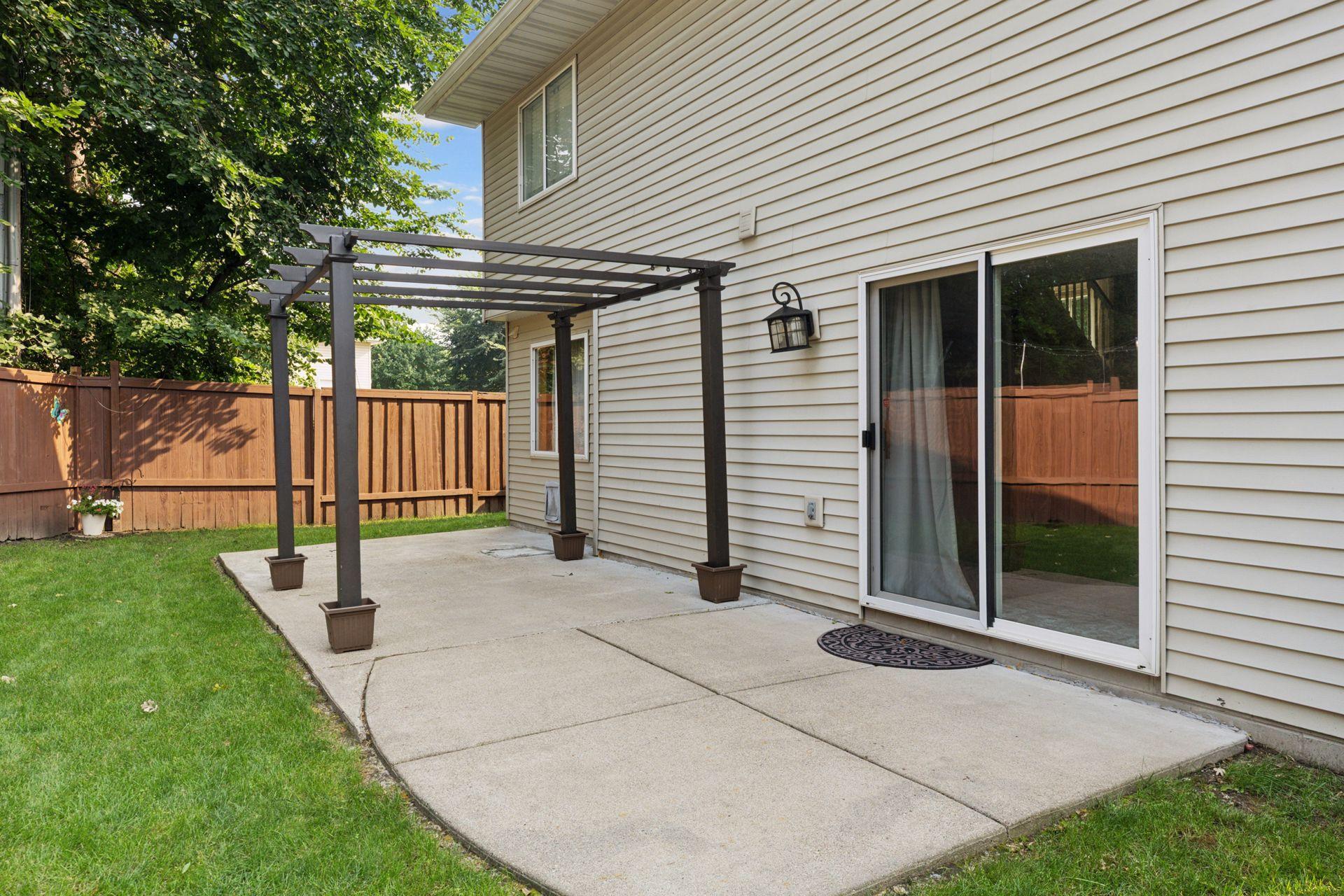 Spacious, fully fenced-in backyard with a concrete patio and additional paver fire pit.