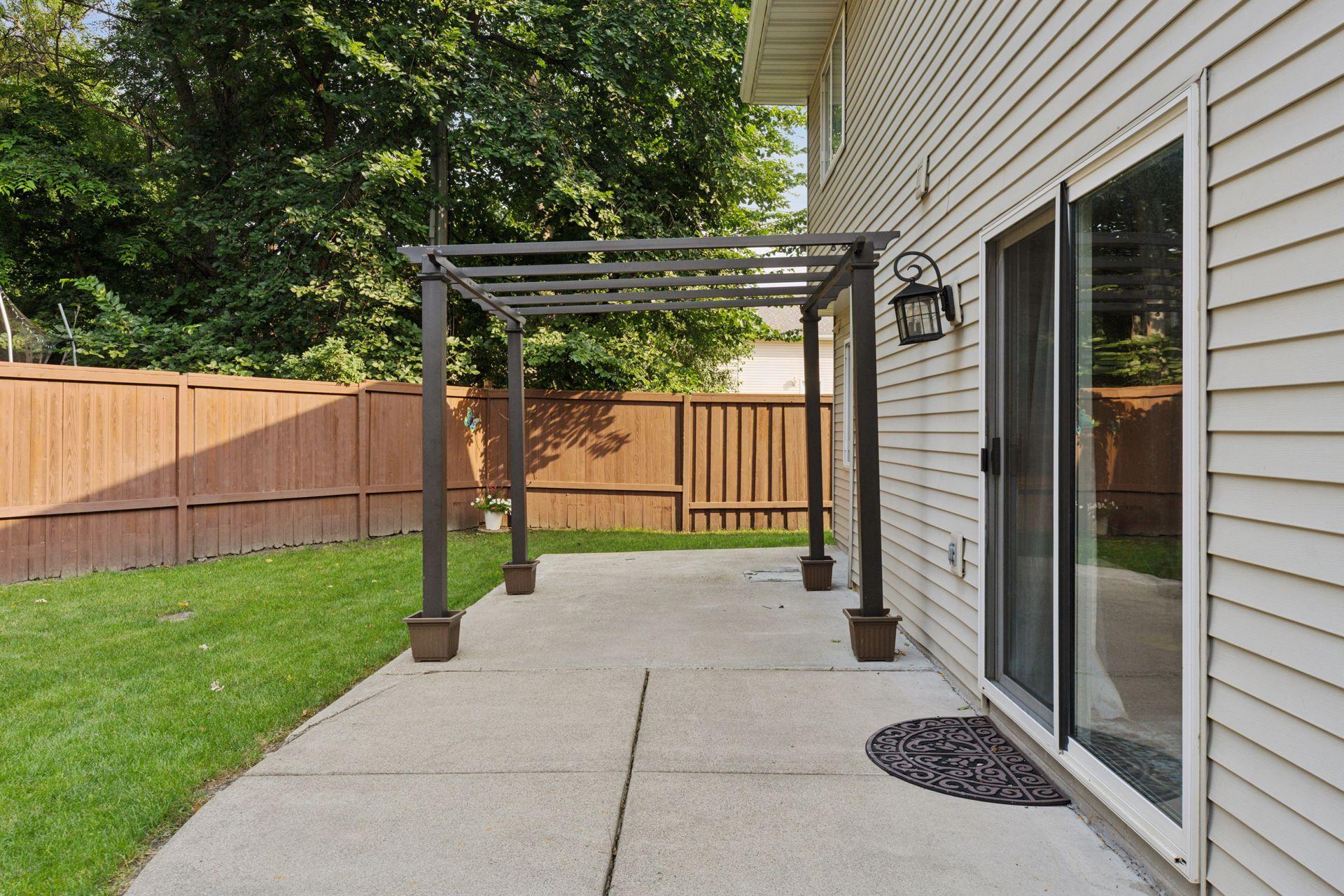 Spacious, fully fenced-in backyard with a concrete patio and additional paver fire pit.
