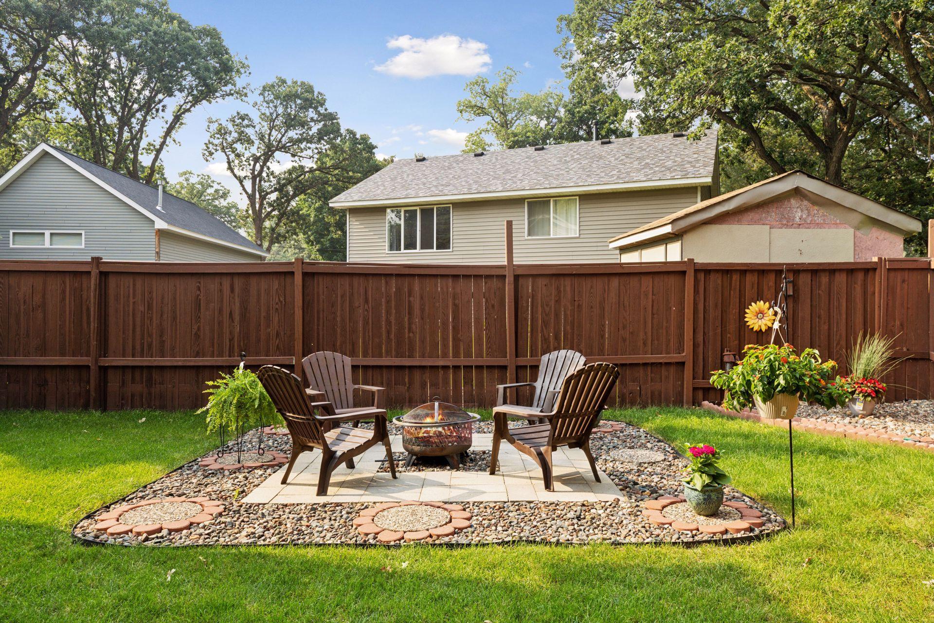 Spacious, fully fenced-in backyard with a concrete patio and additional paver fire pit.