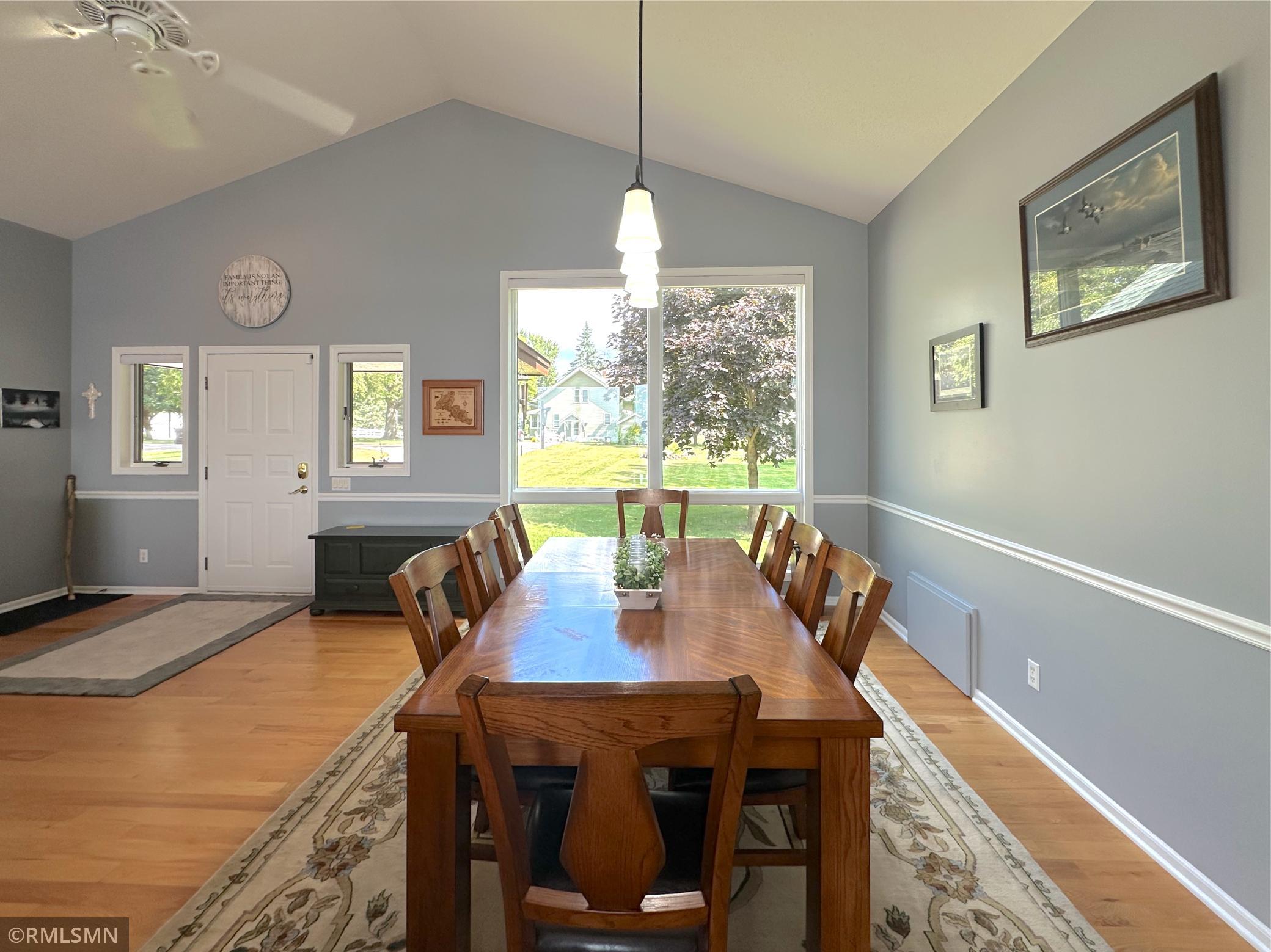 Expansive windows fill the dining room with tons of natural light, highlighting the warmth of the hardwood floors.