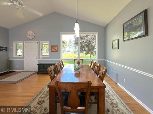 Expansive windows fill the dining room with tons of natural light, highlighting the warmth of the hardwood floors.