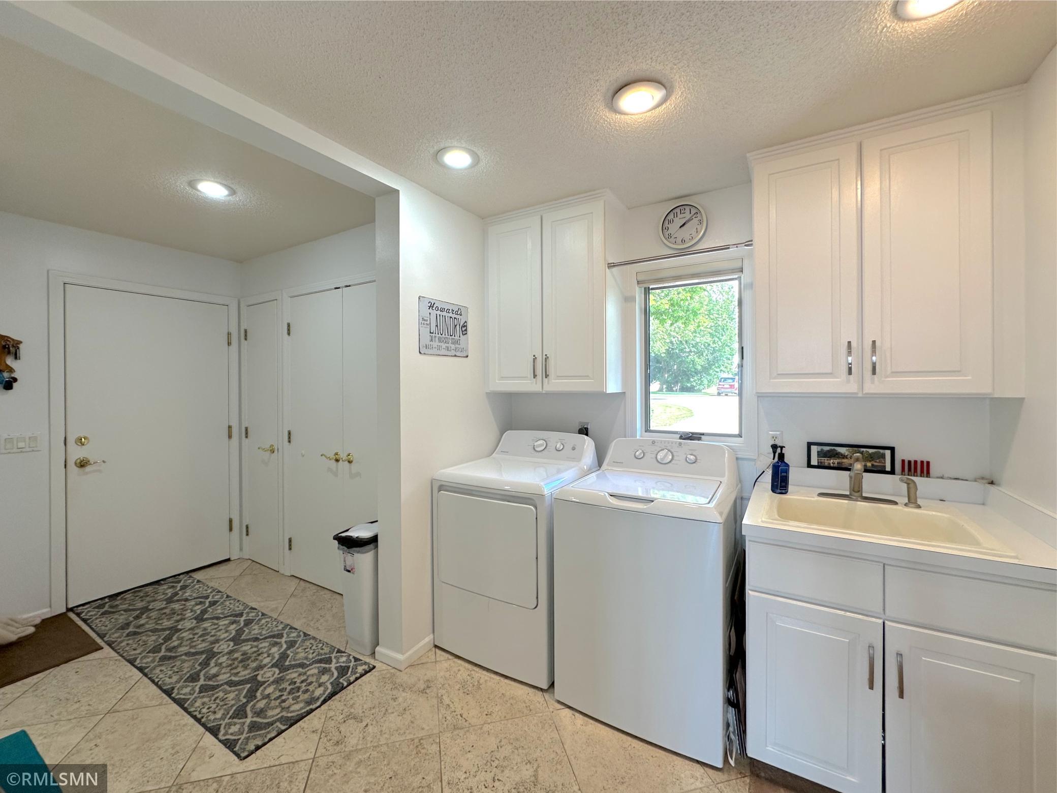 Bright and functional laundry/mud room designed for convenience & organization with ample closets & cabinets.