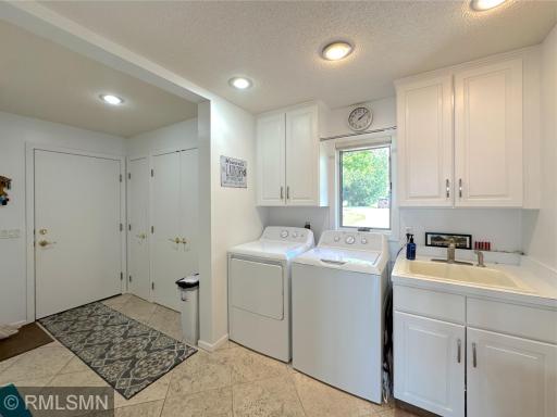 Bright and functional laundry/mud room designed for convenience & organization with ample closets & cabinets.