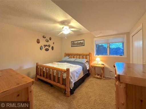 Inviting lower-level bedroom featuring warm neutral tones and a large window brings in wonderful natural light.