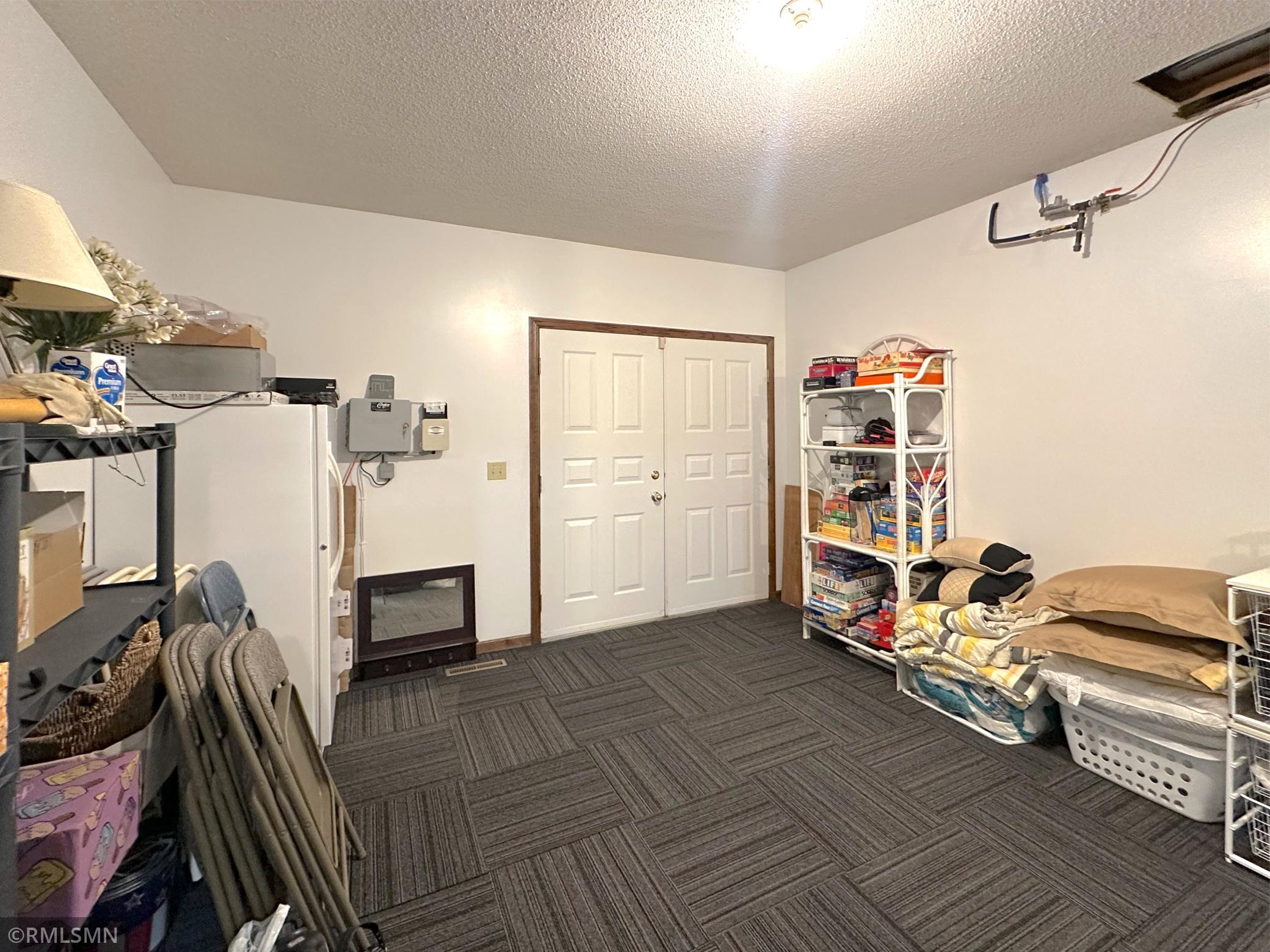 The flex room in the walk-out lower level offers tile carpeting and double doors that lead to the lakeside yard.