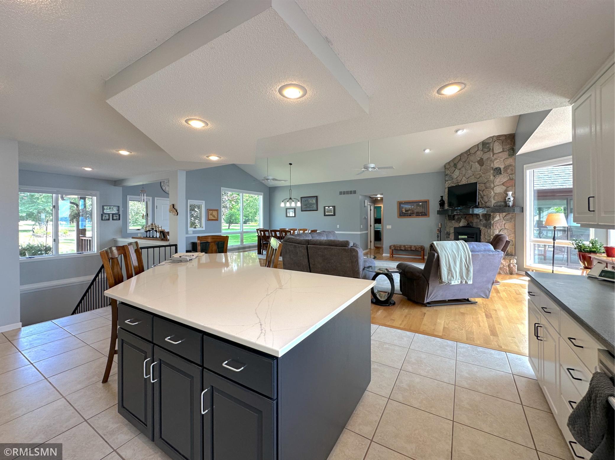 The open layout connects seamlessly to the vaulted dining room, foyer, and living room creating an inviting flow.
