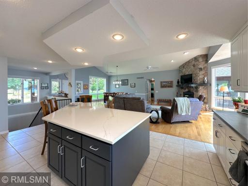 The open layout connects seamlessly to the vaulted dining room, foyer, and living room creating an inviting flow.