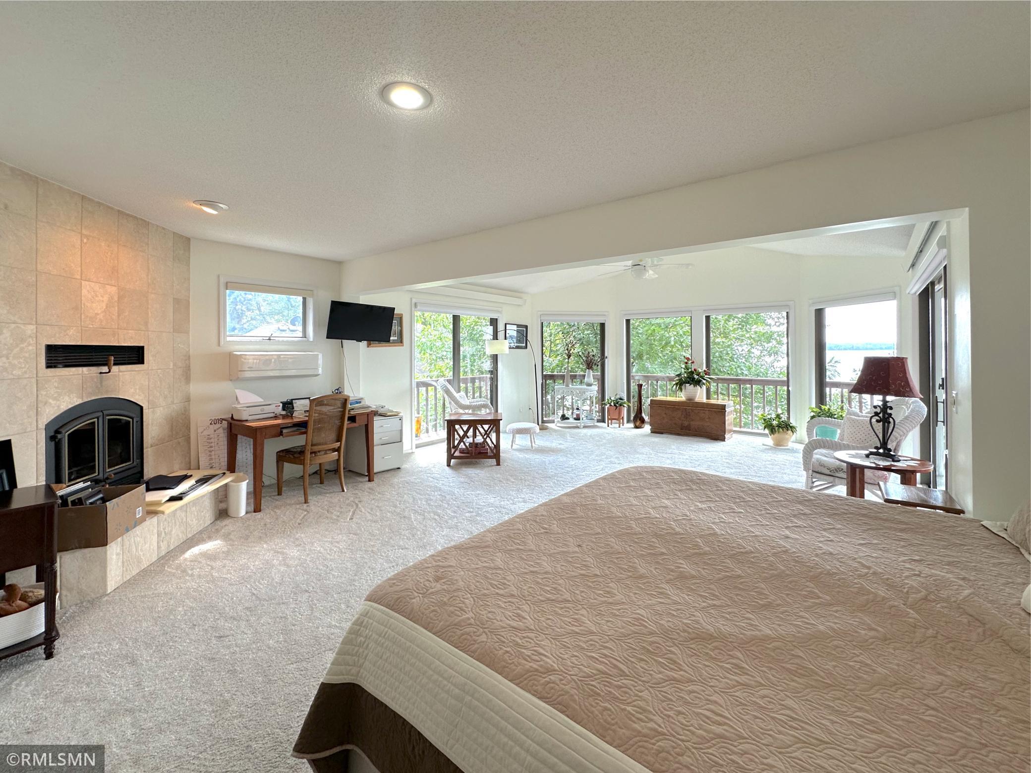 Wake up to stunning lake views in this spacious primary suite, where walls of windows bring the outdoors in.