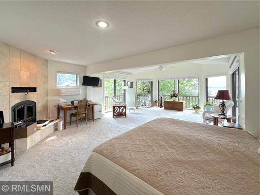 Wake up to stunning lake views in this spacious primary suite, where walls of windows bring the outdoors in.