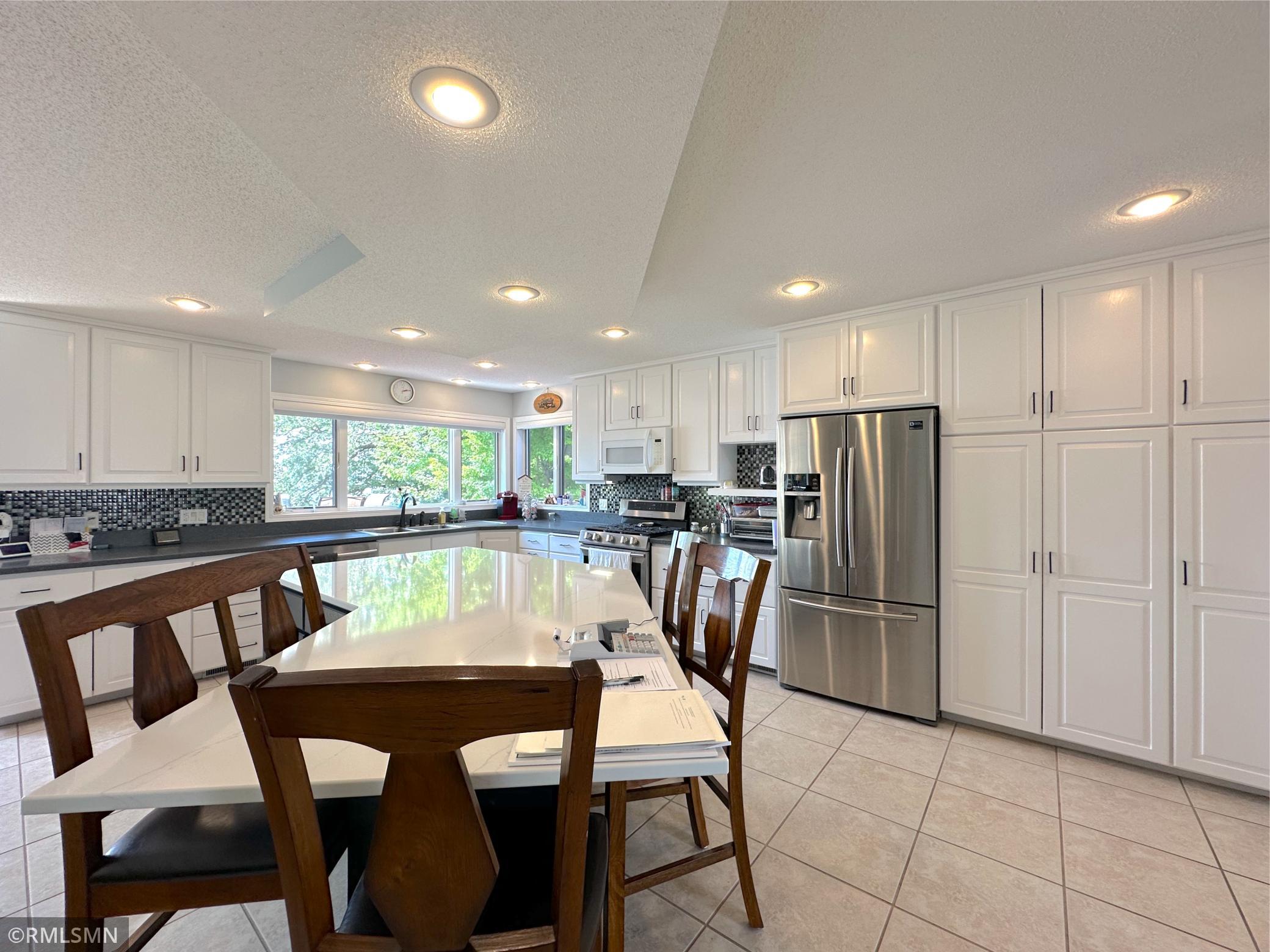 Expansive windows flood the kitchen with natural light while offering serene shoreline views of the outdoors.