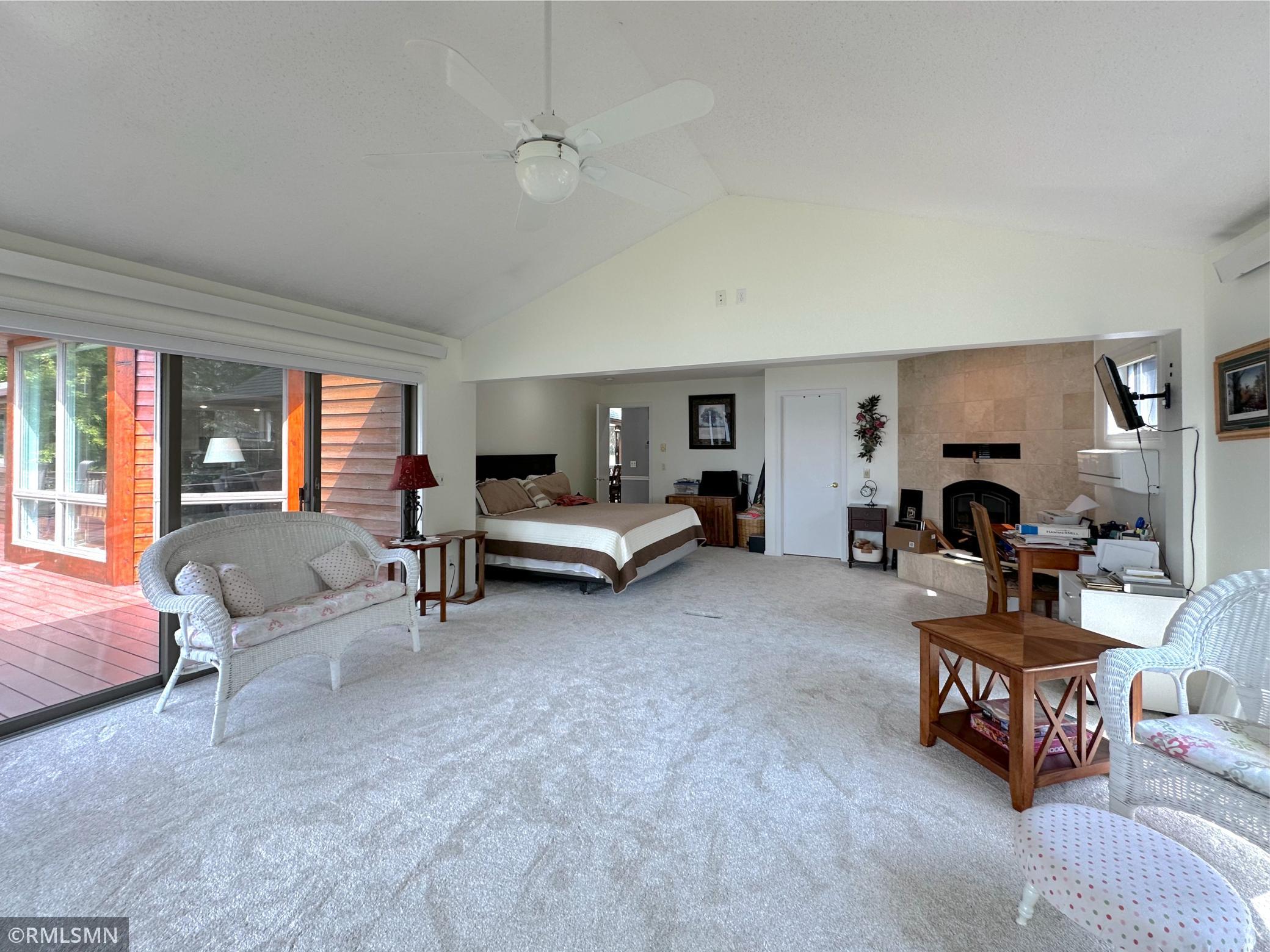 A cozy fireplace adds warmth and charm, while sliding doors open to the spacious lakeside wrap-around deck.