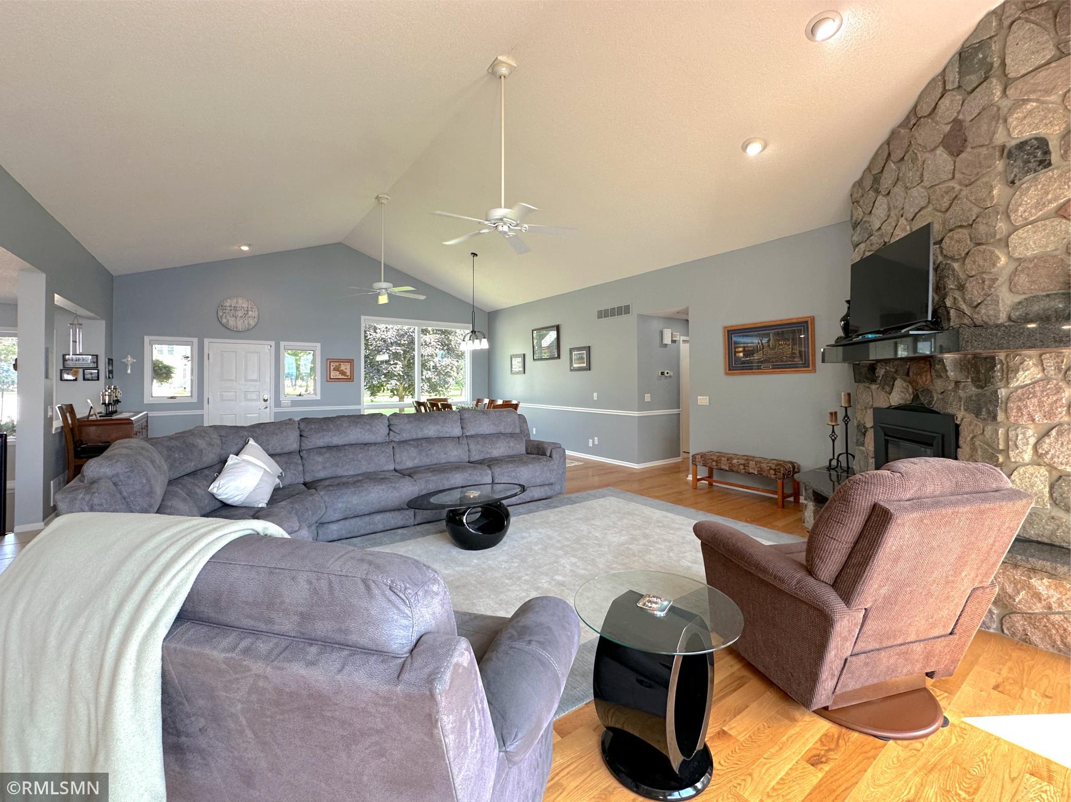 Gather in the spacious living room, where vaulted ceilings and oversized windows fill the space with natural light.