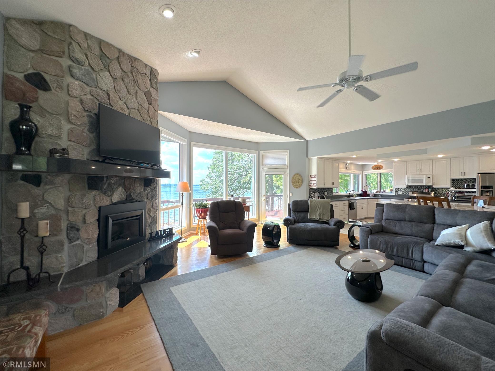 A stunning floor-to-ceiling stone fireplace with stone anchors the room, creating a warm and inviting focal point.