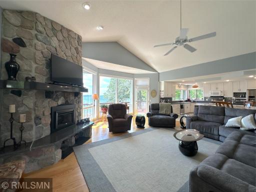 A stunning floor-to-ceiling stone fireplace with stone anchors the room, creating a warm and inviting focal point.
