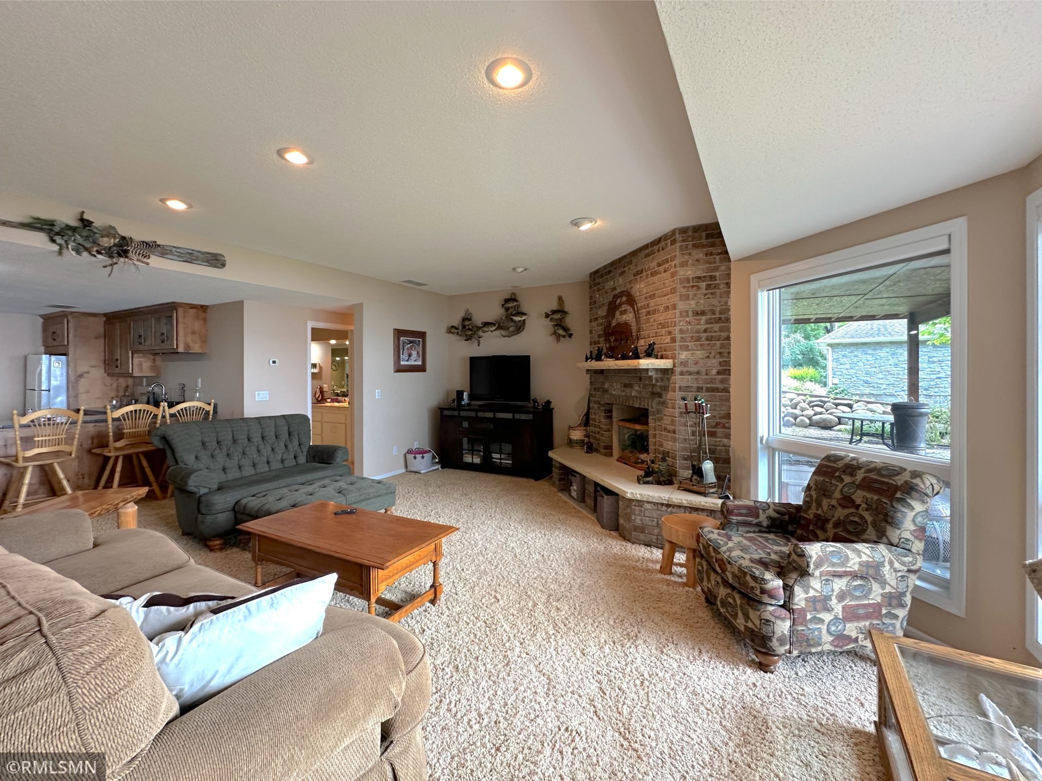 Expansive lower-level family room filled with natural light and stunning lake views through a wall of windows.