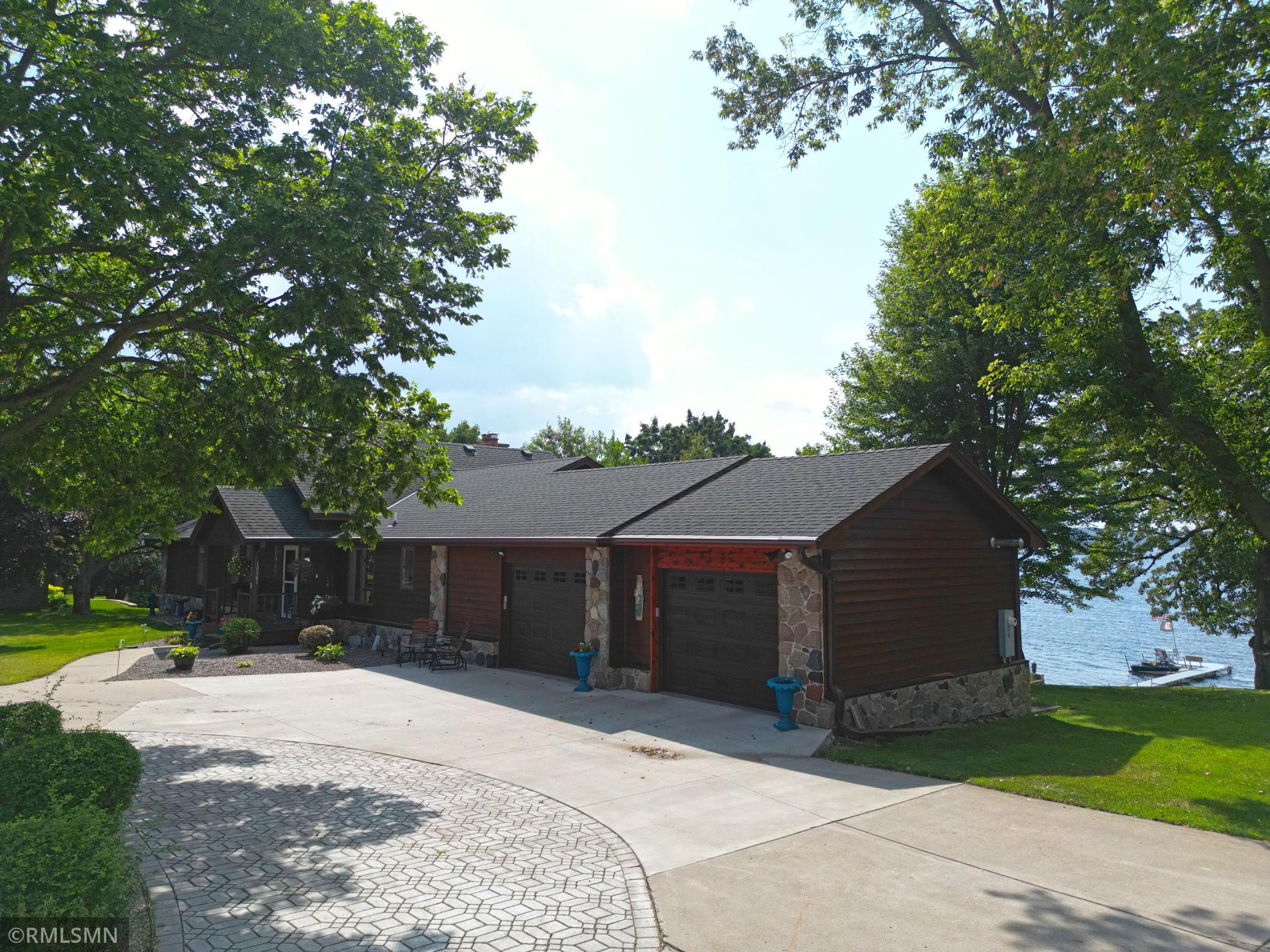 Welcoming curb appeal greets you at this lakeside home featuring mature landscaping and lush green level yard.