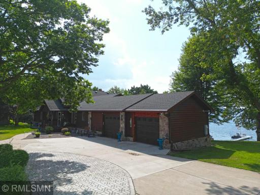 Welcoming curb appeal greets you at this lakeside home featuring mature landscaping and lush green level yard.