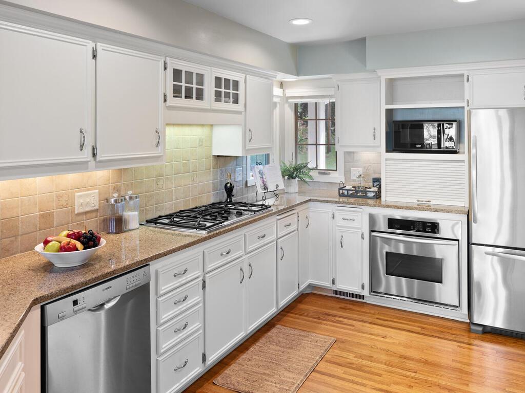 There are enameled cabinets with granite countertops and tile backsplash.