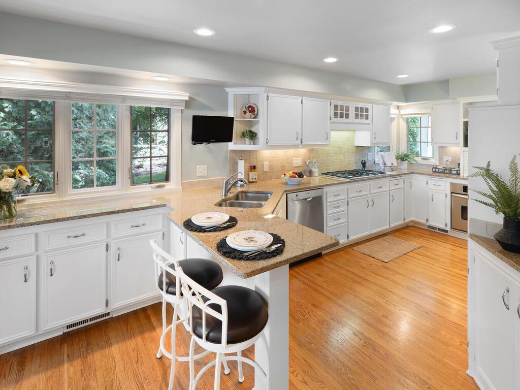 Kitchen has original hardwood flooring beautifully refinished. There are plenty of windows for added light.