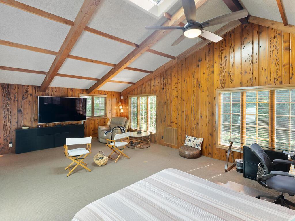 Vaulted third Bedroom has beamed ceiling, ceiling fan and wormwood walls.