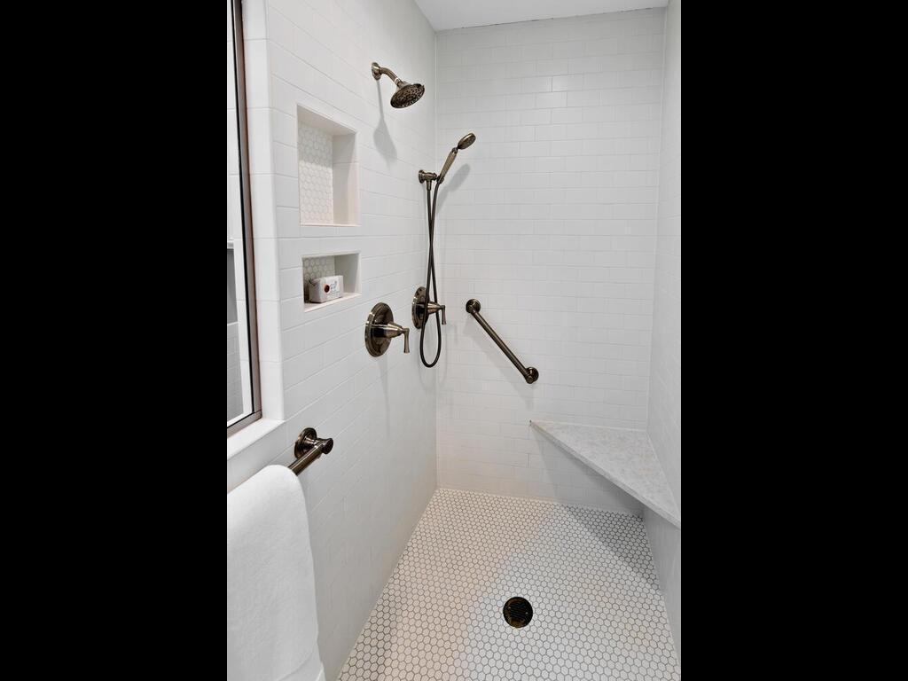 There is a fabulous tile shower with bench and inlayed storage shelving.