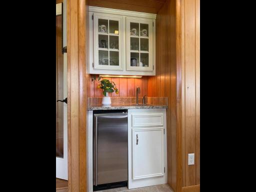 The Room offers a wet bar with stainless steel sink and refrigerator, cabinet with granite countertop and a glass display cabinet with under counter lighting.