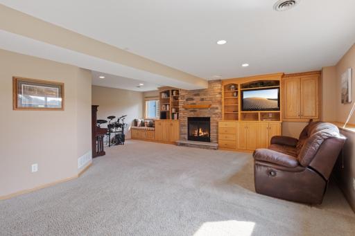 Lower level family room with custom cabinetry and gas-burning fireplace.