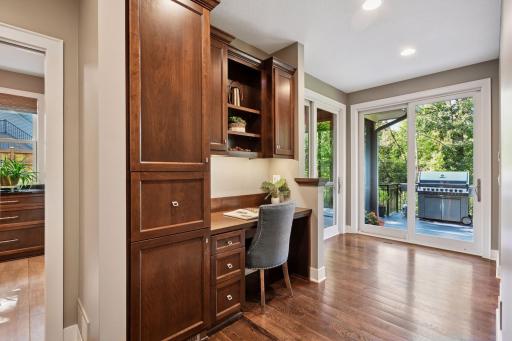 Resource room behind kitchen with built in desk, cabinets and drawers.
