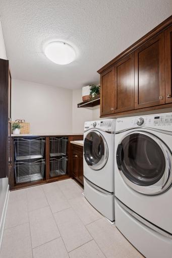 Upper floor laundry with pullout hampers, hanging rod and built-in ironing board.