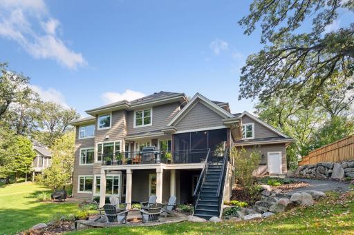 Beautifully landscaped backyard with bolder retaining walls and paver patio with fire pit.