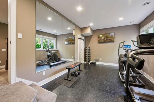 Exercise room with rubber flooring, mirrored wall and closet.